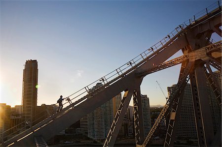 Un grimpeur parcourt les poutres d'acier du pont histoire de Brisbane. Le Story Bridge aventure grimper a ouvert en 2005 et permet aux visiteurs de découvrir une ascension de l'emblématique pont de Brisbane. Photographie de stock - Rights-Managed, Code: 862-03288663