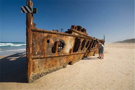 simsearch:862-03288693,k - Ein paar schauen durch verrostete Hulk der Maheno - Passagierschiff, das am Ufer auf Fraser Island durch einen Zyklon im Jahre 1935 geblasen wurde. Stockbilder - Lizenzpflichtiges, Bildnummer: 862-03288708