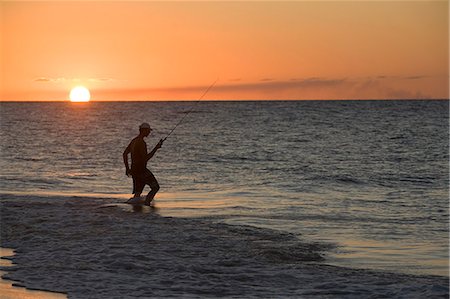fishing silhouette - A fishermen wades into the surf as the sun sets on Fraser Island. Stock Photo - Rights-Managed, Code: 862-03288739