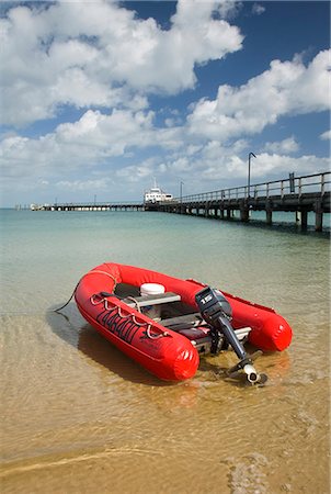 simsearch:862-03288732,k - A red zodiac floats in the clear waters of Kingfisher Bay on Fraser Island. Kingfisher Bay is the main entry point for visitors to the world's largest sand island. Foto de stock - Con derechos protegidos, Código: 862-03288747