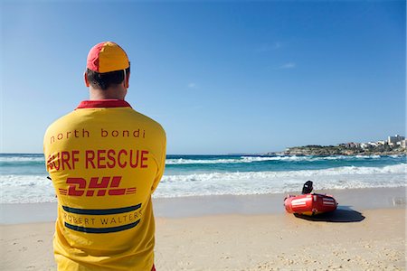 simsearch:862-03288838,k - A lifesaver watches the surf on Bondi Beach in eastern Sydney. Lifesavers are a common sight on Australian beaches,assisting swimmers in distress. Foto de stock - Con derechos protegidos, Código: 862-03288860