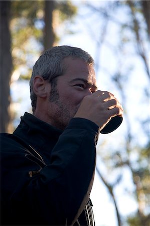 A hiker drinking coffee in the early morning on the Overland Track,Tasmania. . Foto de stock - Con derechos protegidos, Código: 862-03289037