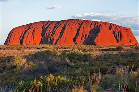 red soil - Australia,Northern Territory. Uluru or Ayres Rock,a huge sandstone rock formation,is one of Australia’s most recognized natural icons. The rock appears to change colour in different lights. Stock Photo - Rights-Managed, Code: 862-03289178