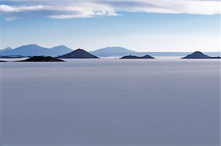 View across the great white expanse that is the Salar de Uyuni,the largest salt flat in the world,towards the distant Andean peaks. Stock Photo - Rights-Managed, Code: 862-03289432