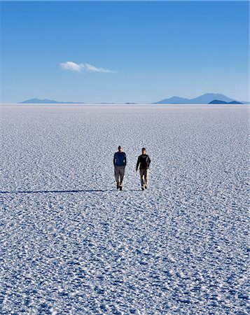 Deux touristes marcher à travers la croûte de sel sans fin du Salar d'Uyuni, le plus grand plat de sel dans le monde à plus de 12 000 kilomètres carrés. Photographie de stock - Rights-Managed, Code: 862-03289471