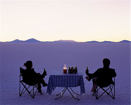 Tourists enjoy sundowners while looking out across the endless salt crust of the Salar de Uyuni,the largest salt flat in the world at over 12,000 square kilometres. Stock Photo - Rights-Managed, Code: 862-03289472