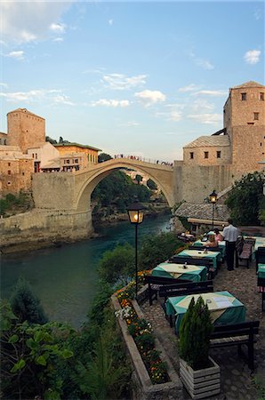 La réplique du pont de la paix Balkans Bosnie Mostar Stari Most de pont en pierre du XVIe siècle détruite par les Croates de bombardements en 1993 et ouvert en 2004 Restaurant donnant sur pont et rivière Photographie de stock - Rights-Managed, Code: 862-03289487