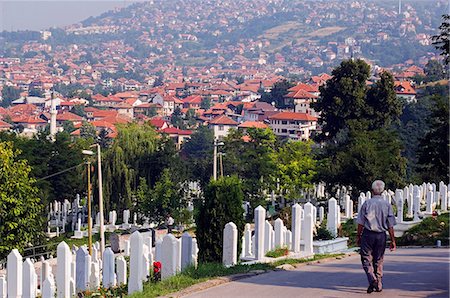 Homme de Sarajevo marchant dans le cimetière surplombant des maisons de ville Photographie de stock - Rights-Managed, Code: 862-03289505