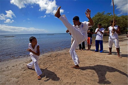 simsearch:862-03289805,k - Brésil, Bahia, île de Boipeba. Garçons et les jeunes hommes s'entraînent au Capoeira la danse martiale de danse ritualiste esclave du Brésil où mouvements par étapes masquer les positions de combats, postures défensifs et offensifs jabs. Photographie de stock - Rights-Managed, Code: 862-03289789