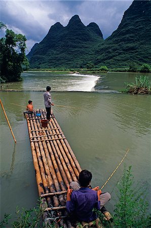 Yulong River,Nr Yangshuo,Guangxi ProvinceVillage boys fish from a bamboo raft. This picturesque river is set amidst some of South China's finest karst scenery Stock Photo - Rights-Managed, Code: 862-03289888