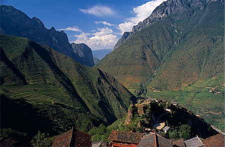 Perched high above the upper reaches of the Yangtse,this Naxi village boasts a superb setting on the slopes of a deep valley. Kublai Khan is said to have crossed the river near hear on one of his campaigns Foto de stock - Con derechos protegidos, Código: 862-03289901