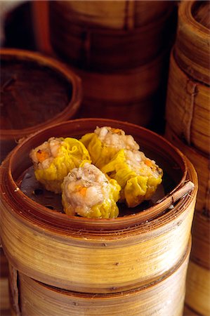 dim sum - Dim sum delicacies are stacked in steaming bamboo baskets in a Kowloon restaurant,Hong Kong Foto de stock - Con derechos protegidos, Código: 862-03289946