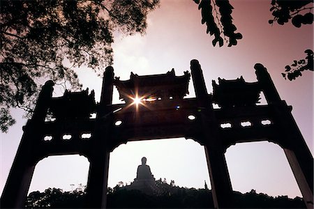 The Tian Tan Buddha,sitting atop a Lantau peak,is framed by a chinese gate at Ngong Ping. The giant Buddha sculpture is the largest,outdoor seated bronze Buddha in the world. Stock Photo - Rights-Managed, Code: 862-03289985