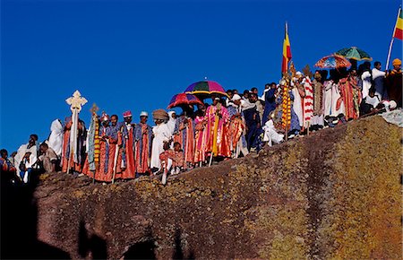 simsearch:862-03354009,k - Ethiopian Christmas day celebrations (Genna),Bet Maryam Church,Lalibela,Ethiopia. Holy men carry Axunite hand crosses. Cloths are used when holding these,to keep them clean. Colourful umbrellas are also an important part fo the religious symbolism employed in Ethiopia. Foto de stock - Con derechos protegidos, Código: 862-03354028