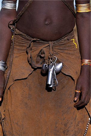 A young Dassanech girl wears a leather skirt,metal bracelets and amulets and layers of bead necklaces. Much the largest of the tribes in the Omo Valley numbering around 50,000,the Dassanech (also known as the Galeb,Changila or Merille) are Nilotic pastoralists and agriculturalists. Stock Photo - Rights-Managed, Code: 862-03354076