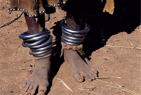 simsearch:862-06676735,k - A young Dassanech girl wears heavy metal anklets beneath her beaded leather skirt. Much the largest of the tribes in the Omo Valley numbering around 50,000,the Dassanech (also known as the Galeb,Changila or Merille) are Nilotic pastoralists and agriculturalists. Stock Photo - Rights-Managed, Code: 862-03354077