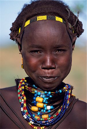 A young Dassanech girl wears a beautiful array of beaded necklaces. Much the largest of the tribes in the Omo Valley numbering around 50,000,the Dassanech (also known as the Galeb,Changila or Merille) are Nilotic pastoralists and agriculturalists. Stock Photo - Rights-Managed, Code: 862-03354078