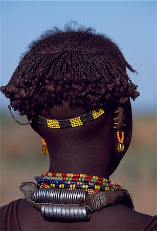 ethiopian people - A young Dassanech girl wears a beautiful array of beaded necklaces,some secured at the back by metal rings,and a beaded headband. Her ears are pierced several times,the holes are kept open by small wooden plugs. Much the largest of the tribes in the Omo Valley numbering around 50,000,the Dassanech (also known as the Galeb,Changila or Merille) are Nilotic pastoralists and agriculturalists. Stock Photo - Rights-Managed, Code: 862-03354079