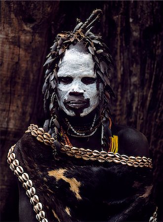 photography traditional face paint - A Karo woman wears an elaborate headdress made from the wing-cases of beetles and a cape of calf skin fringed with cowrie shells. A small Omotic tribe related to the Hamar,who live along the banks of the Omo River in southwestern Ethiopia,the Karo are renowned for their elaborate body painting using white chalk,crushed rock and other natural pigments. Stock Photo - Rights-Managed, Code: 862-03354097