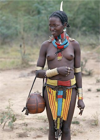 A Bena girl in magnificent turnout. Her handbag is a finely decorated gourd.The Bena are a small tribe living in remote Southwest Ethiopia. Stock Photo - Rights-Managed, Code: 862-03354115