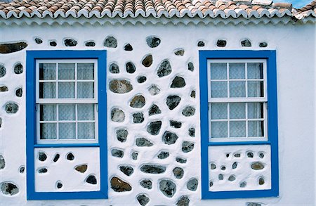 Detail of windows on a whitewashed house with inset volcanic stone and a blue frame in Santo Domingo de Garafia Foto de stock - Con derechos protegidos, Código: 862-03354217