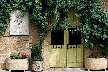 simsearch:862-03354331,k - L'entrée de la Muga Winery est recouverte d'une vigne et flanquée de Pierre et de pots de fleurs en céramique Photographie de stock - Rights-Managed, Code: 862-03354347
