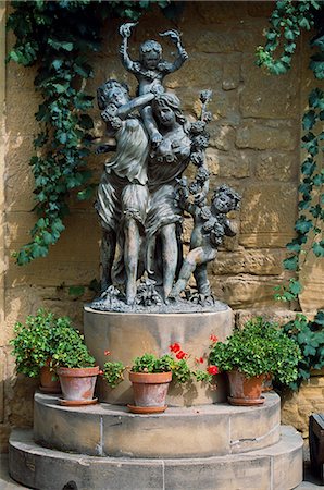 A statue of girls and children holding grapes to celebrate the wine harvest stands beside the entrance to Muga Winery on a stone plinth surrounded by flower pots Foto de stock - Con derechos protegidos, Código: 862-03354348