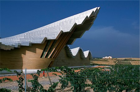 simsearch:862-03354346,k - The striking centre-piece Ysios winery,designed by world renowned architect Santiago Calatrava,protrudes from the undulating aluminium roof like the prow of a ship Foto de stock - Con derechos protegidos, Código: 862-03354364