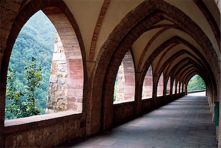 An arched cloister in The Monastery of Santa Maria de Valvanera sits in a quiet side valley of the Rio Najerilla. Dating back as far as the 9th Century,the current temple was built in the 15th century with additions to the monastery in the 20th Century Foto de stock - Con derechos protegidos, Código: 862-03354375