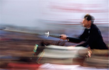 saint john - A rider on horseback speeds through the crowd attempting to strike a target with a lance. The event called ensortilla is part of the Festival of Sant Joan that is celebrated in Ciutadella,on the island of Menorca Foto de stock - Con derechos protegidos, Código: 862-03354480