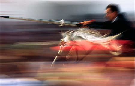 simsearch:862-03354522,k - A rider on horseback speeds through the crowd attempting to strike a target with a lance. The event held in Ciutadella on the Balearic Island of Menorca is part of the festival of Sant Joan (Saint John) that celebrates the island's cavallers (horsemen). Foto de stock - Con derechos protegidos, Código: 862-03354482