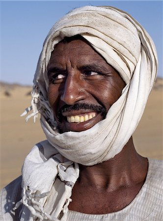 A Nubian man wearing a white turban smiles broadly at his friend. Fotografie stock - Rights-Managed, Codice: 862-03354615