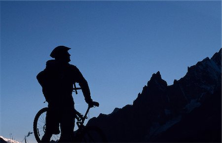 A cyclist on a mountain bike tour of Mont Blanc,looking across on Val Ferret. Stock Photo - Rights-Managed, Code: 862-03354662