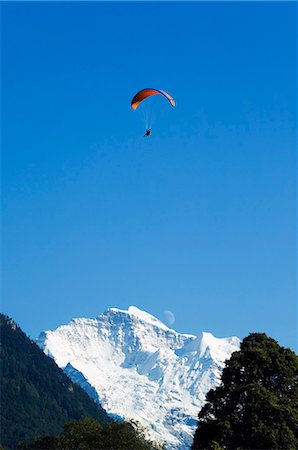 A paraglider flies over a moon rising above the Jungfrau Mountain Range,Interlaken,Jungfrau Region,Switzerland Foto de stock - Con derechos protegidos, Código: 862-03354696