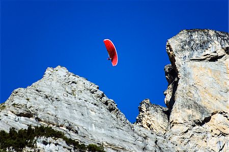 parasailing - A paraglider sails through high mountains in the Interlaken Valley,Interlaken,Jungfrau Region,Switzerland Stock Photo - Rights-Managed, Code: 862-03354690