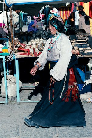 rueda de oración - A young Tibetan woman strolls the Barkhor,the holiest of Lhasa's circumambulatory devotional routes Foto de stock - Con derechos protegidos, Código: 862-03354990