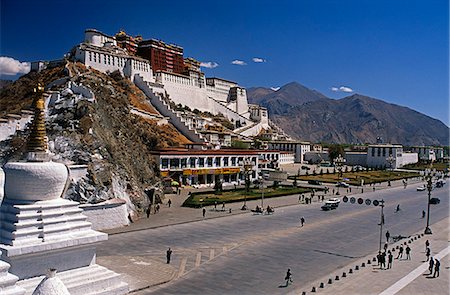 Potala Palace - rising from the slopes of Marpori,or Red Mountain,the Potala Palace was reconstructed in two main phases in the 17th century. Named after Mt Potala,the sacred mountain abode of Avalokiteshvara,the Potala has functioned as the traditional seat of government and winter residence of the Dalai Lamas,as well as housing temples and reliquary tombs Foto de stock - Con derechos protegidos, Código: 862-03354991