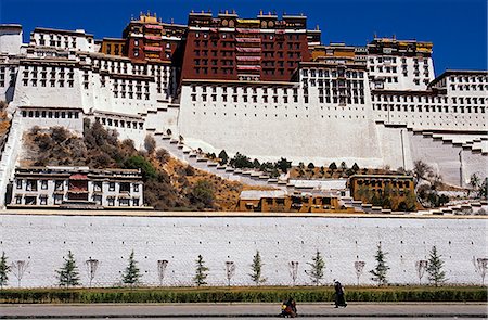 Potala Palace - rising from the slopes of Marpori,or Red Mountain,the Potala Palace was reconstructed in two main phases in the 17th century. Named after Mt Potala,the sacred mountain abode of Avalokiteshvara,the Potala has functioned as the traditional seat of government and winter residence of the Dalai Lamas,as well as housing temples and reliquary tombs Stock Photo - Rights-Managed, Code: 862-03354992