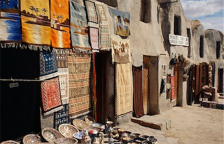 Tunisie, Médenine. Une fois parmi les plus importants berbère du Sud bourgs, ksar de Medenine grenier fortifié, fut l'une des plus grandes et miel-peigné avec 8000 ghorfas, ou des cellules de stockage des céréales et des objets de valeur. Quelques-uns servent aujourd'hui de magasins de bibelots pour touristes. Photographie de stock - Rights-Managed, Code: 862-03355026