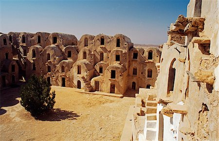 Tunisia,Jebel Abiadh. This restored ksar,or fortified granary,is amongst Tunisia's finest examples of this type of architecture. Hundreds of ghorfas,or storage cells,traditionally faced with palm wood doors enclose the main courtyard. Stock Photo - Rights-Managed, Code: 862-03355042