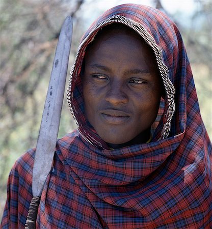 Un jeune homme Datoga, lance à la main, a décoré les bords de son enveloppe de coton cocher avec fermetures éclair vieux.Le Datoga (connu pour leurs voisins Maasai comme le Mang'ati et le Iraqw comme Babaraig) vivent dans le nord de la Tanzanie et sont principalement des éleveurs. Photographie de stock - Rights-Managed, Code: 862-03355179