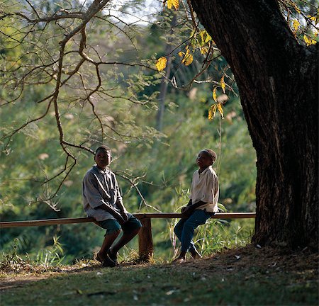 Two young boys relax on a low wooden fence at a river near Iringa. Stock Photo - Rights-Managed, Code: 862-03355188