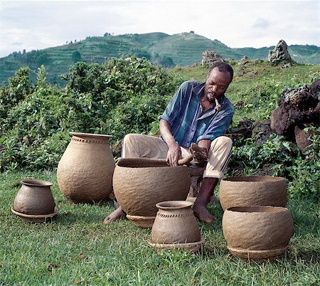 A potter fashions cooking pots by the coil method,shaping them by eye alone. Surprisingly,craft skills such as pottery and basket-making are the sole preserve of men in Southwest Uganda. Stock Photo - Rights-Managed, Code: 862-03355425