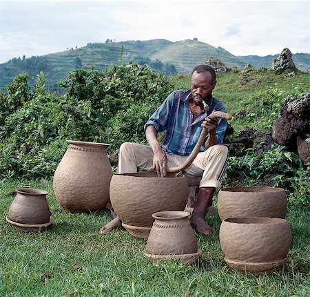 Un potier façonne des marmites par la méthode de la bobine, mise en forme de l'oeil seul. Étonnamment, les métiers comme la poterie et la vannerie sont l'apanage exclusif des hommes dans le sud-ouest de l'Ouganda. Photographie de stock - Rights-Managed, Code: 862-03355426