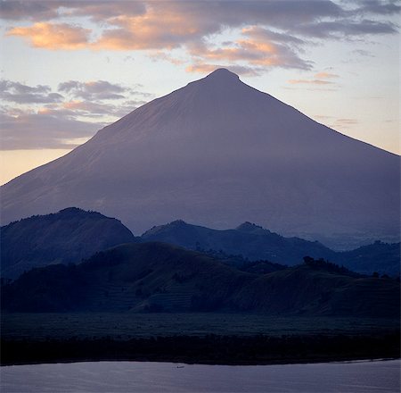 simsearch:862-03808741,k - Photographed from Lake Mutanda at sunrise,Mount Muhavura looms like a huge pyramid to a height of 13,540 feet. It is the most easterly of the Virunga Volcanoes and straddles the Uganda-Rwanda border.. . Foto de stock - Direito Controlado, Número: 862-03355435