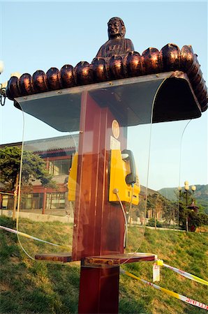 A Buddha decorates a telephone box at Shaolin temple birthplace of Kung Fu martial arts,Henan Province,China Stock Photo - Rights-Managed, Code: 862-03351082