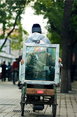 China,Beijing. A woman transporting a window pane; in a local neighbourhood Hutong. Stock Photo - Rights-Managed, Code: 862-03351338