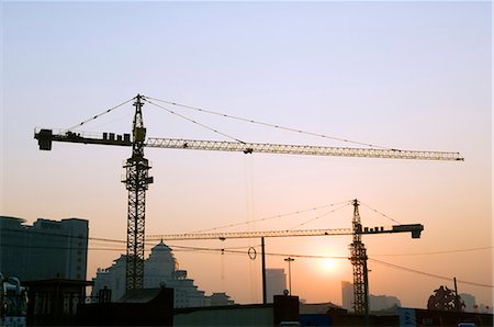 China,Beijing. Sunset over a construction site's cranes. Stock Photo - Rights-Managed, Code: 862-03351330