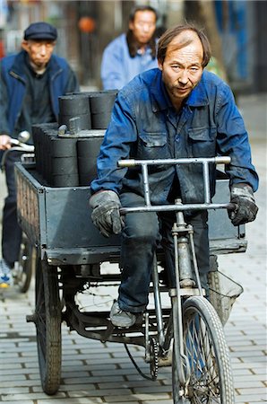 simsearch:862-03351372,k - Chine, Beijing. Hommes transportant des briques de charbon de bois dans un quartier Hutong. Photographie de stock - Rights-Managed, Code: 862-03351340