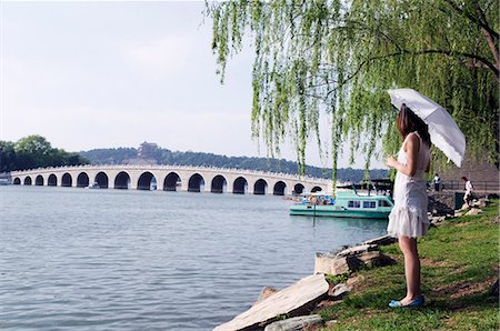 summer palace - China,Beijing,Summer Palace - Unesco World Heritage Site. A young girl looking at the 17 arch bridge . Foto de stock - Con derechos protegidos, Código: 862-03351441